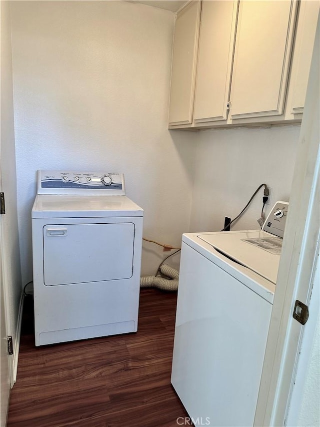 clothes washing area with dark wood-type flooring, independent washer and dryer, and cabinets