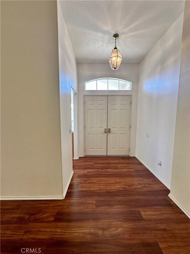 foyer featuring a textured ceiling and dark wood-type flooring