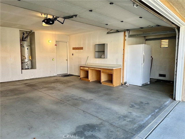 garage featuring a garage door opener, white refrigerator, and strapped water heater