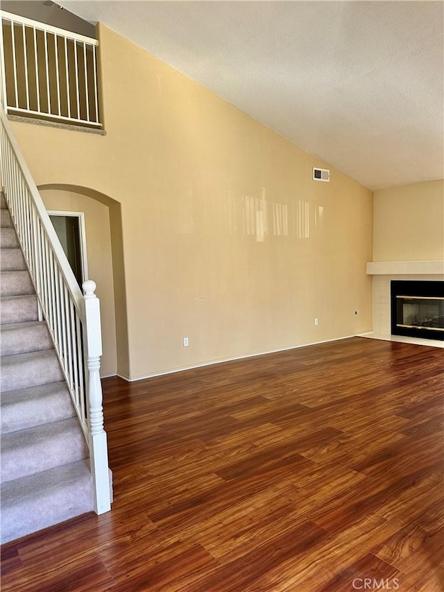 unfurnished living room featuring lofted ceiling and hardwood / wood-style flooring