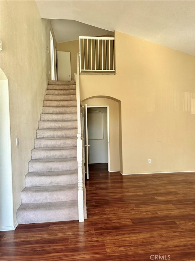 stairs with lofted ceiling and hardwood / wood-style floors