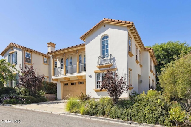 mediterranean / spanish house with a garage and a balcony