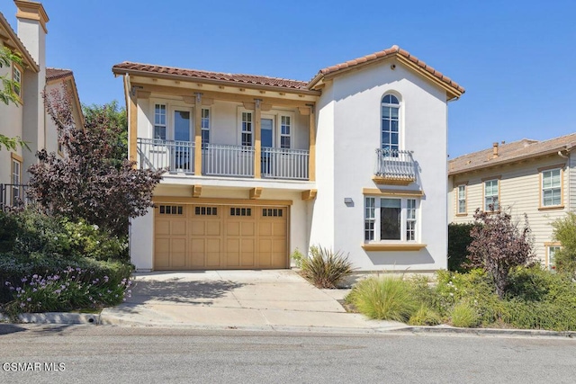 mediterranean / spanish-style home featuring a garage and a balcony