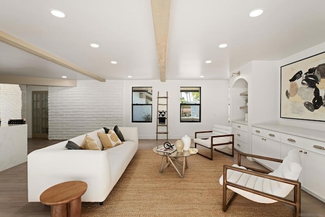 living room featuring brick wall, wood-type flooring, and beam ceiling