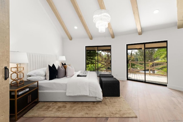 bedroom featuring wood-type flooring, multiple windows, a chandelier, and access to exterior