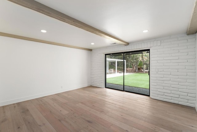 spare room with brick wall, light wood-type flooring, and beam ceiling