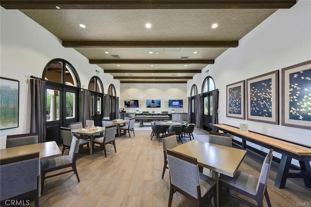 dining room with light wood-type flooring and beamed ceiling