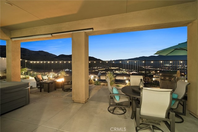 patio terrace at dusk featuring a mountain view