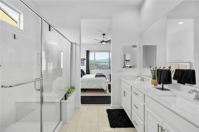 bathroom featuring ceiling fan, a wealth of natural light, a shower with door, and vanity