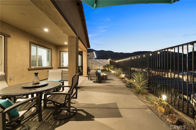 patio terrace at dusk featuring a mountain view