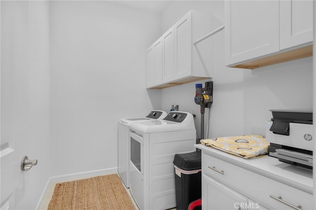 laundry area with washing machine and dryer and cabinets