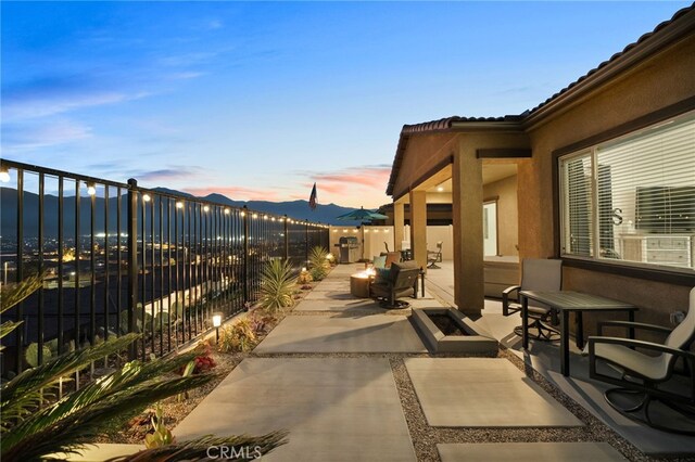 patio terrace at dusk featuring a mountain view