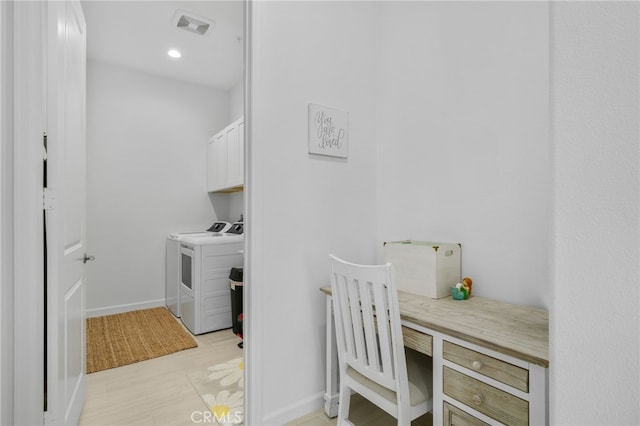 laundry room featuring washing machine and dryer and cabinets