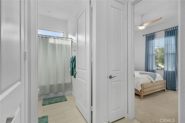 bathroom featuring ceiling fan and shower / tub combo