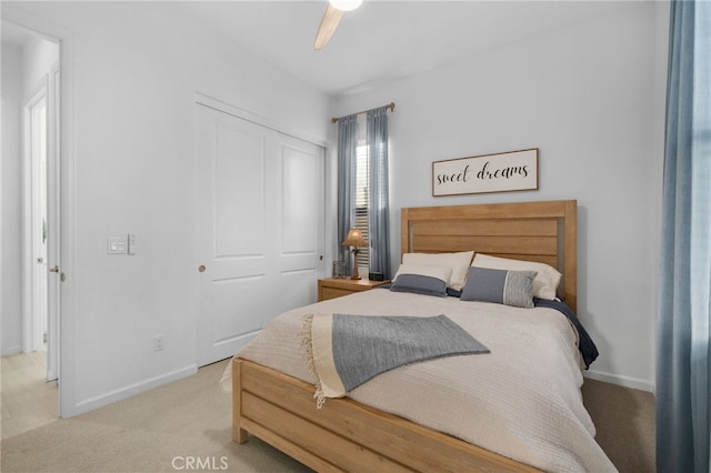 bedroom featuring ceiling fan, a closet, and light carpet