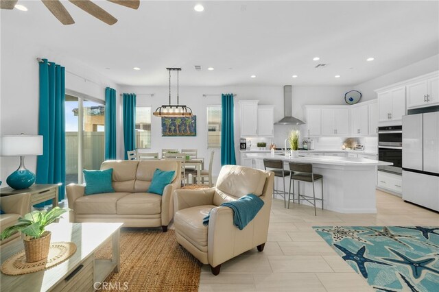 living room with ceiling fan and sink