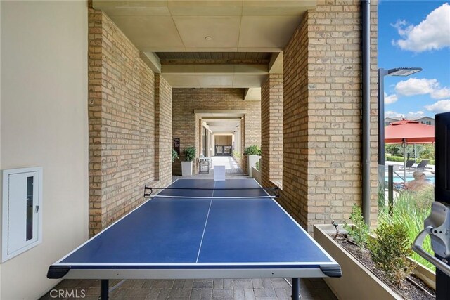 recreation room with brick wall