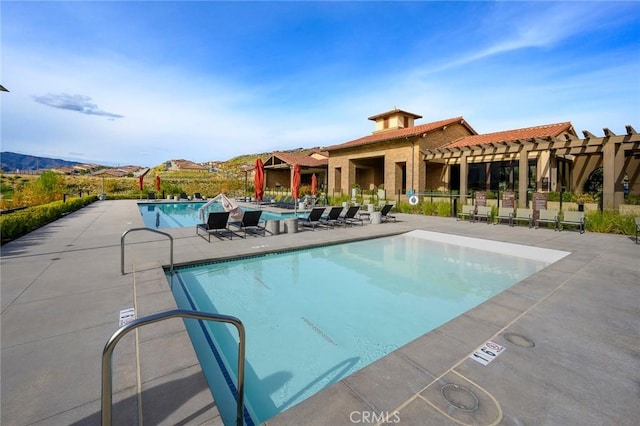 view of swimming pool with a mountain view, a patio area, and a pergola