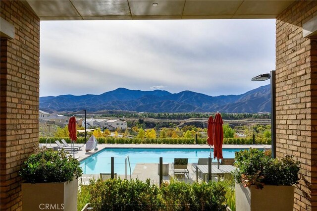 view of swimming pool with a mountain view