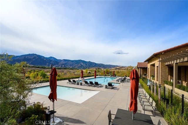 view of swimming pool with a mountain view and a patio area