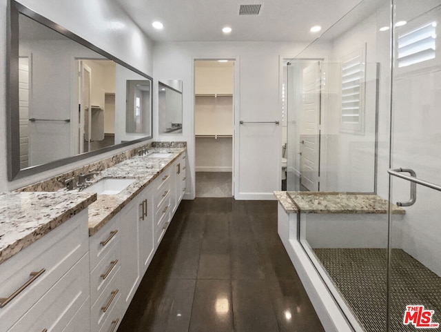 bathroom with walk in shower and vanity