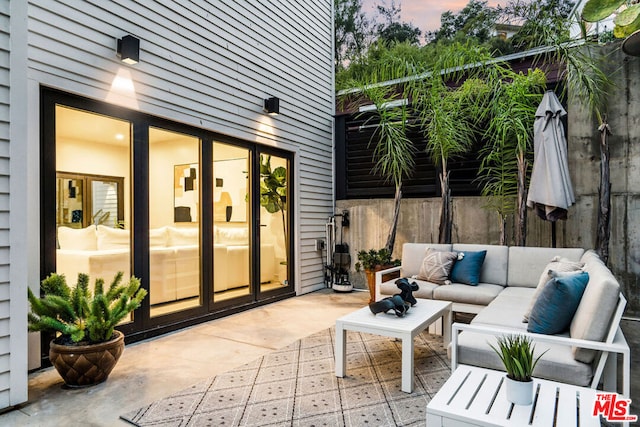 patio terrace at dusk featuring an outdoor hangout area