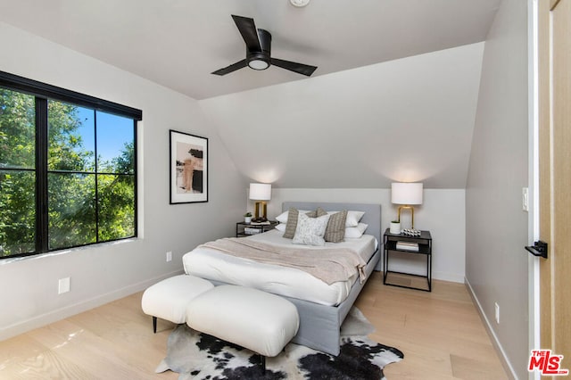 bedroom featuring ceiling fan, light wood-type flooring, and lofted ceiling