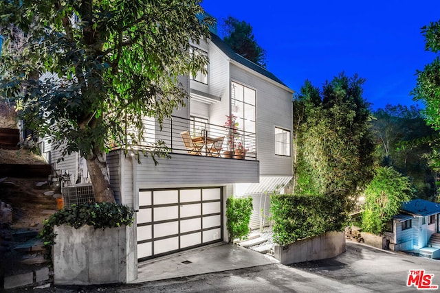 view of front of home with a garage and a balcony