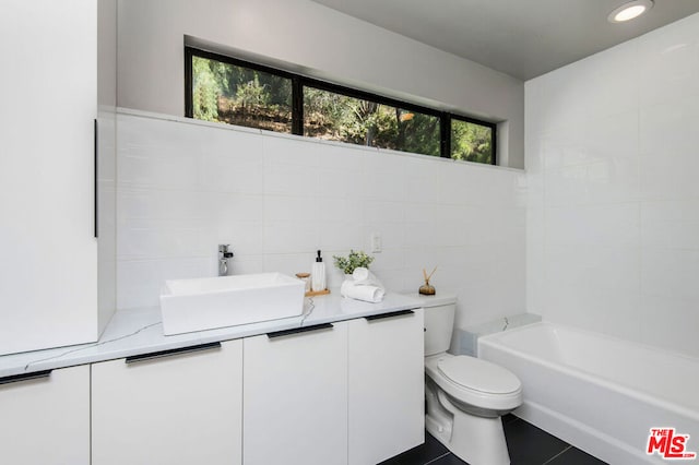 bathroom with toilet, a bath, vanity, and tile patterned flooring