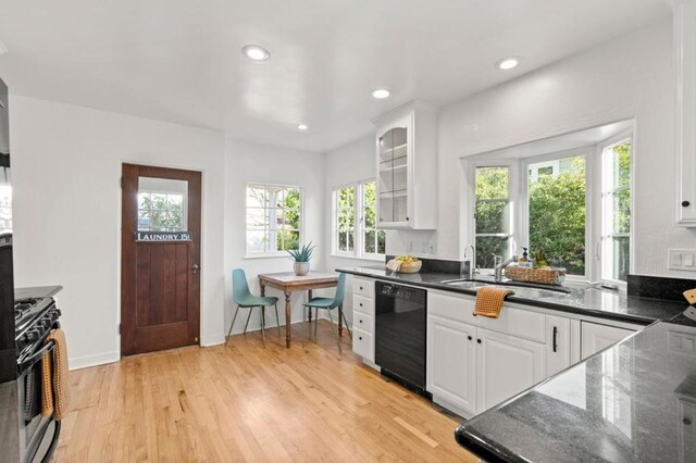 kitchen featuring sink, light hardwood / wood-style flooring, black dishwasher, gas stove, and white cabinets