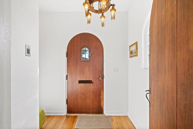 foyer with an inviting chandelier and light hardwood / wood-style flooring