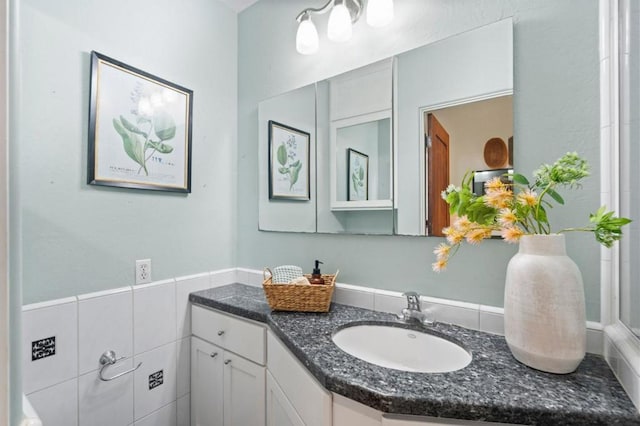 bathroom with vanity and tile walls