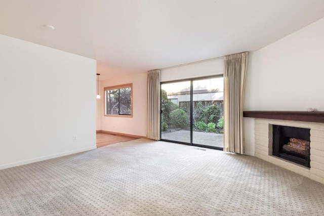 unfurnished living room with a brick fireplace and light carpet