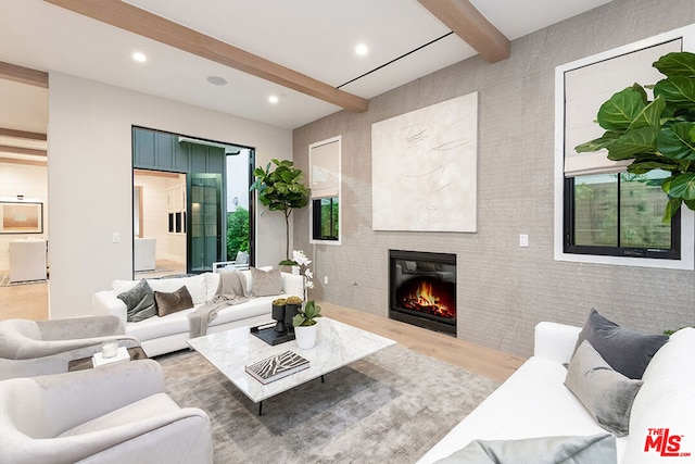 living room featuring beam ceiling and light hardwood / wood-style floors