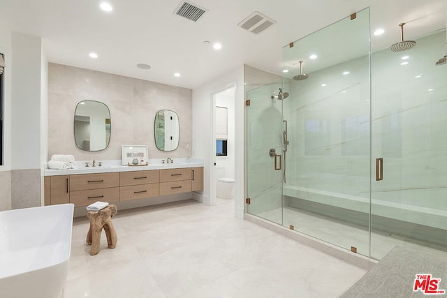 bathroom featuring vanity, toilet, tile walls, and an enclosed shower