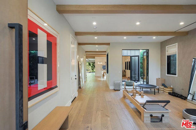 hallway with light wood-type flooring and beam ceiling