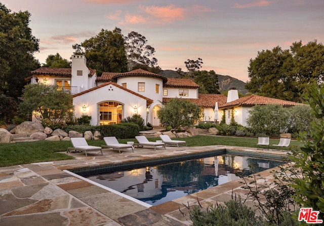 pool at dusk featuring a patio area