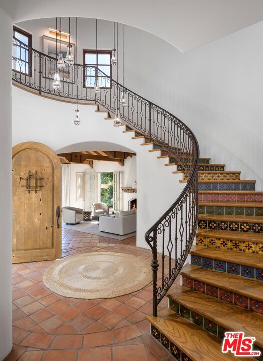 staircase with tile patterned floors and a towering ceiling