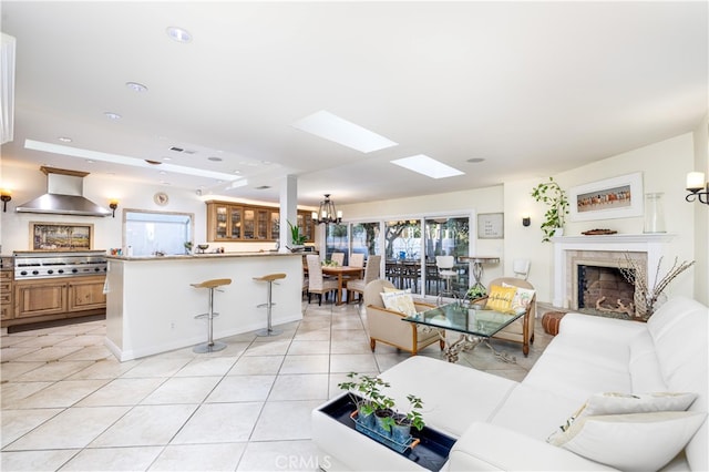 tiled living room with a tray ceiling and an inviting chandelier