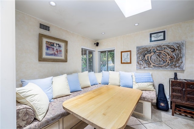 interior space with a skylight and light tile patterned flooring