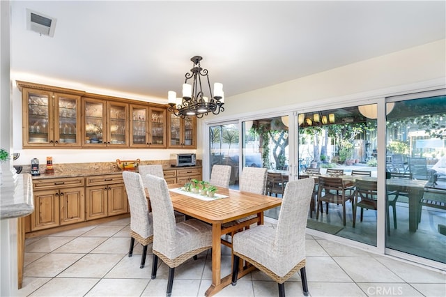 dining space featuring light tile patterned floors and a notable chandelier