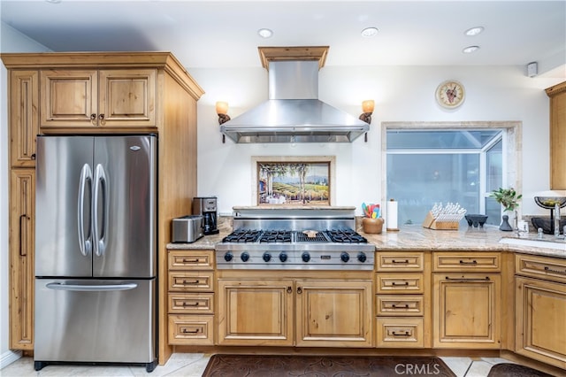 kitchen with light tile patterned floors, appliances with stainless steel finishes, range hood, light stone counters, and sink