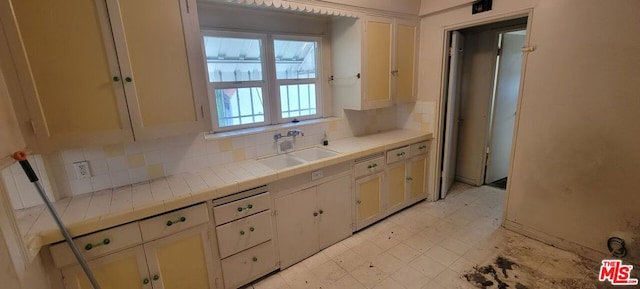 kitchen with sink, backsplash, and tile countertops