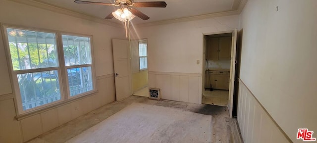 unfurnished room with ceiling fan and ornamental molding