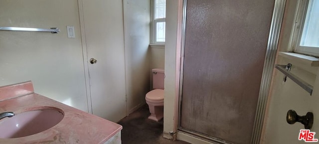 bathroom featuring toilet, a shower with door, and vanity