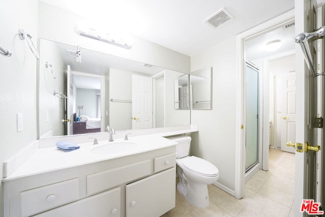 bathroom featuring toilet, a shower with door, and vanity