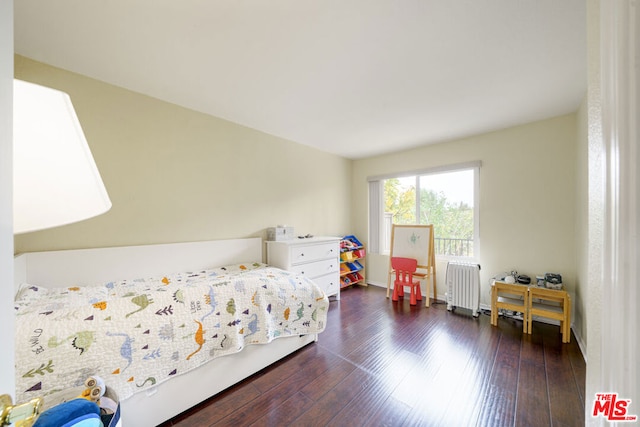 bedroom with radiator and dark hardwood / wood-style floors