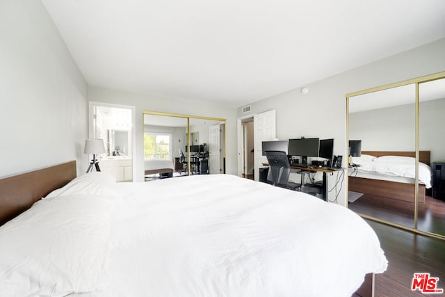 bedroom featuring connected bathroom, dark hardwood / wood-style floors, and multiple closets