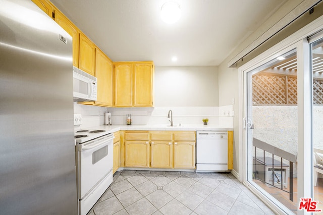 kitchen featuring sink, white appliances, and light brown cabinets