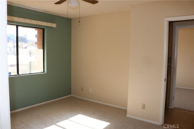 spare room with ceiling fan and light colored carpet